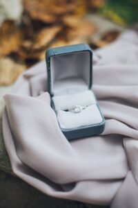 An elegant diamond ring in an open jewelry box resting on soft fabric, evoking love and commitment.